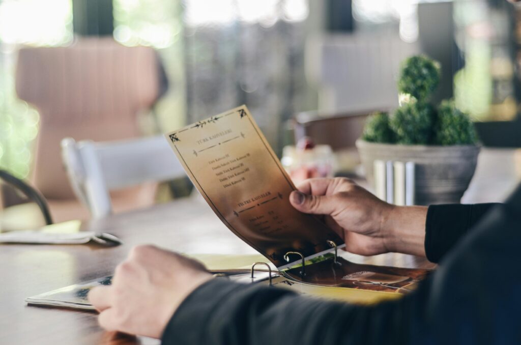 A person reading a menu in a contemporary restaurant, highlighting dining culture.