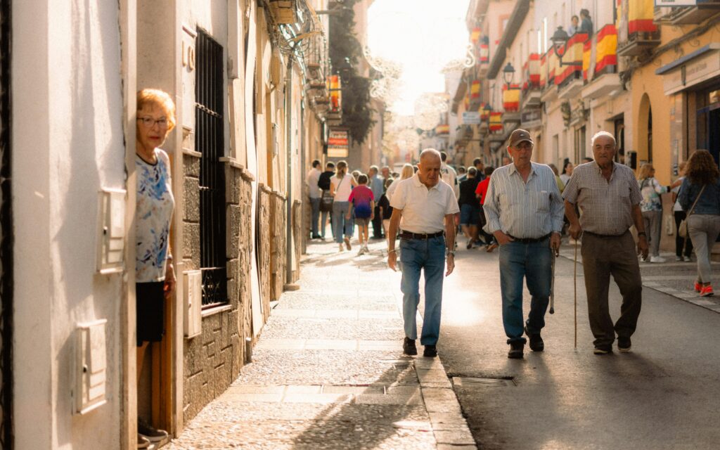 Elderly people walking on a sunny day in Arganda del Rey, showcasing local culture.