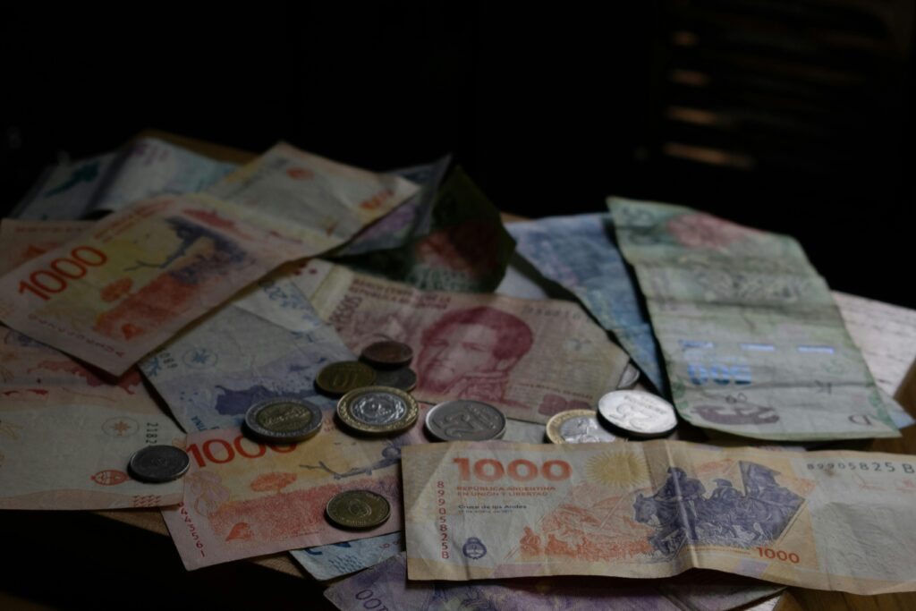 A collection of various international banknotes and coins scattered on a table.