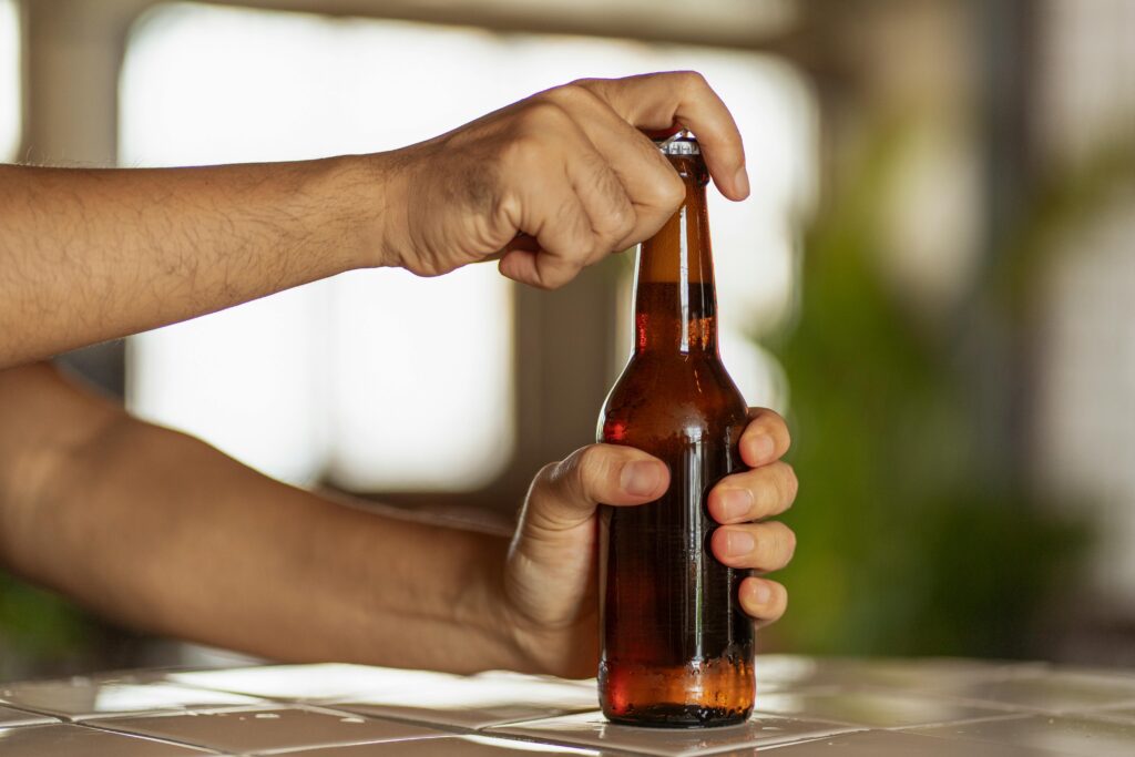 Hands opening a beer bottle, showcasing the moment of anticipation.