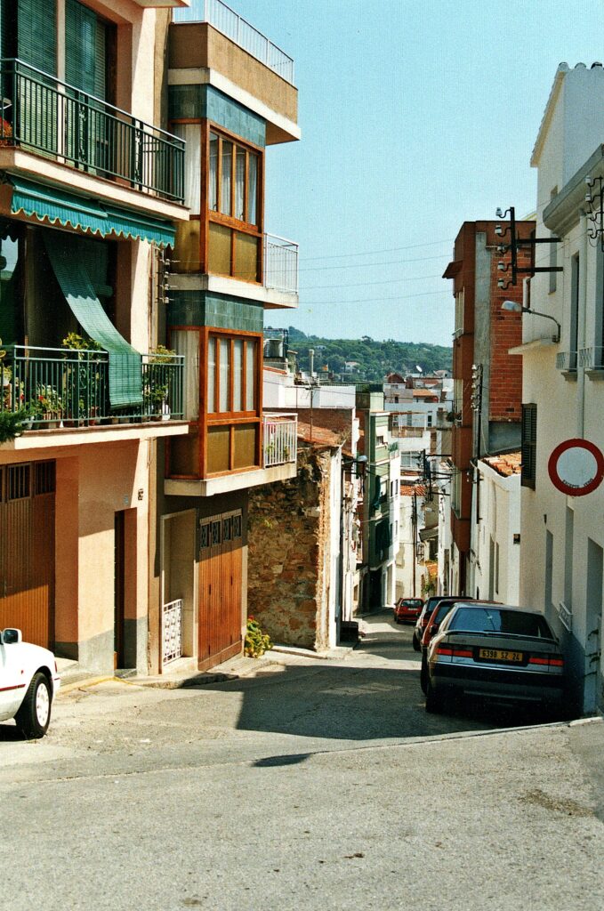 A picturesque urban street scene in Lloret de Mar, showcasing colorful buildings under a sunny sky.