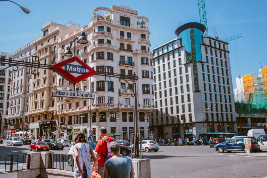 Busy urban life at Plaza de España with iconic architecture and Metro sign.