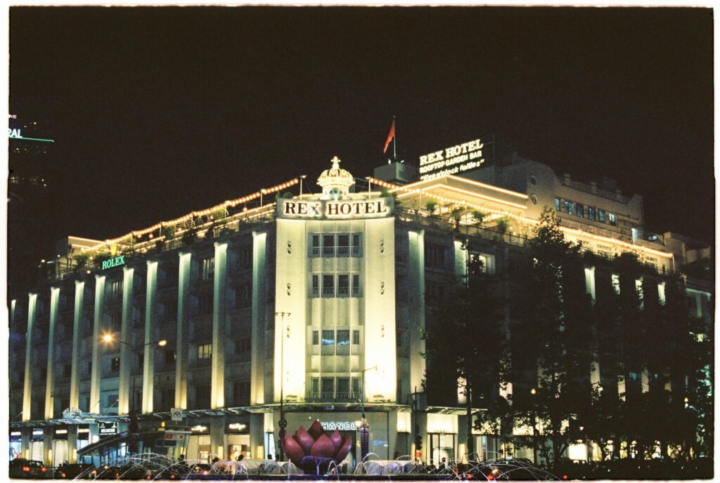 Night view of the illuminated Rex Hotel in Saigon, Vietnam, showcasing its architectural elegance.