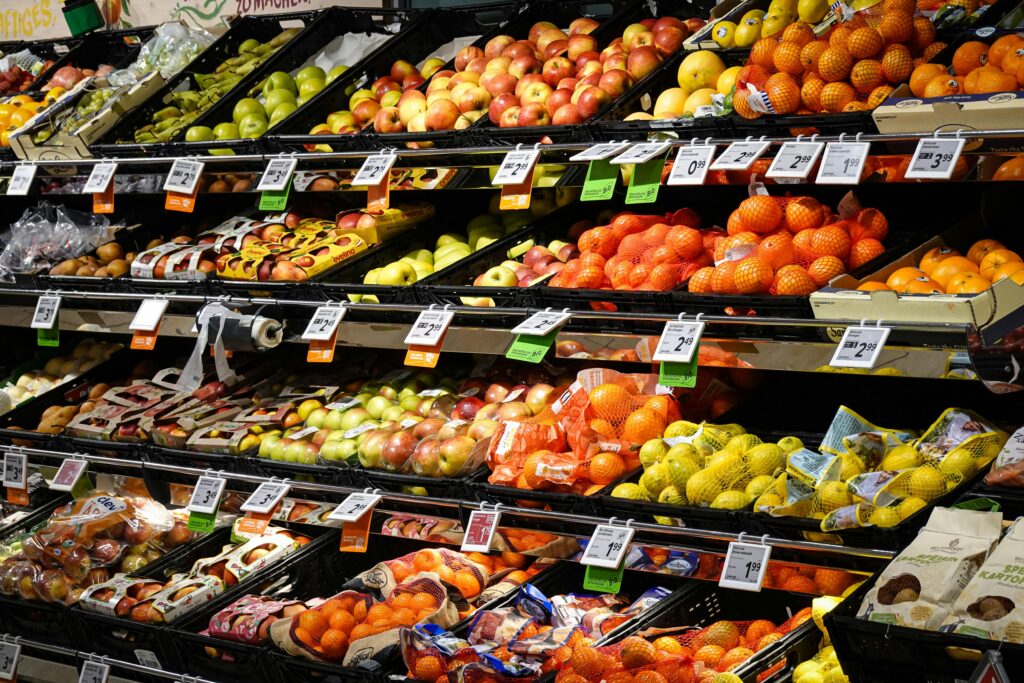 Colorful assortment of fresh fruits neatly arranged on supermarket shelves, ideal for healthy eating themes.