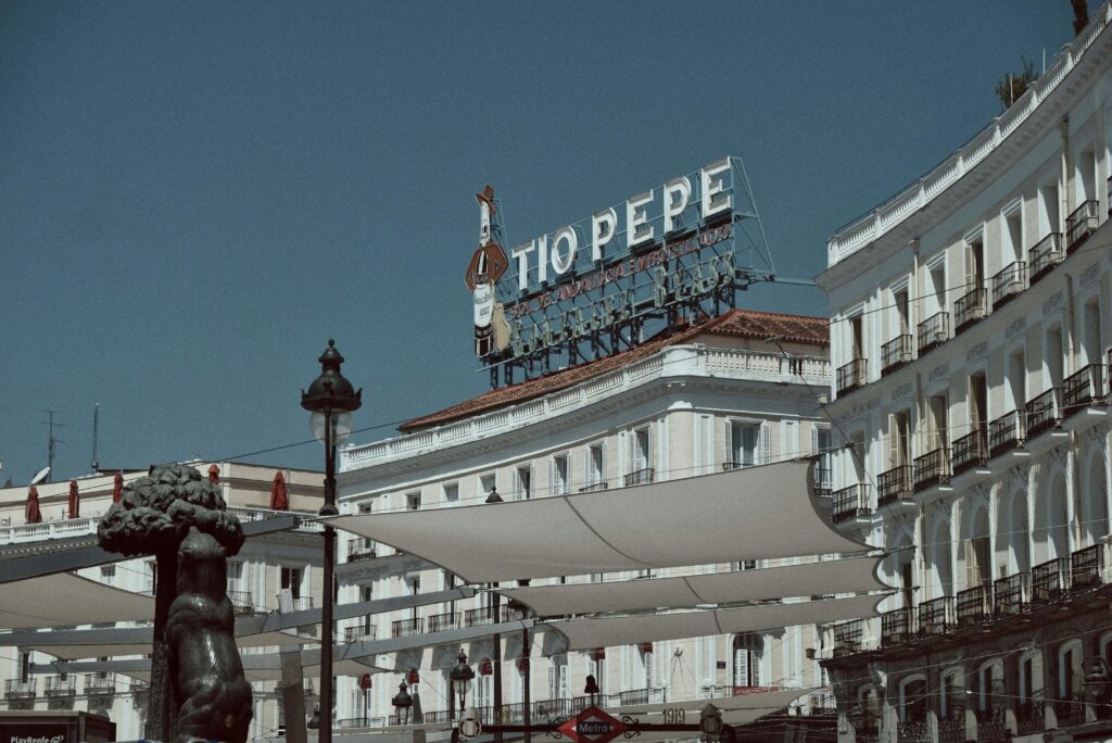 View of Puerta del Sol featuring the iconic Tio Pepe sign in central Madrid, Spain.